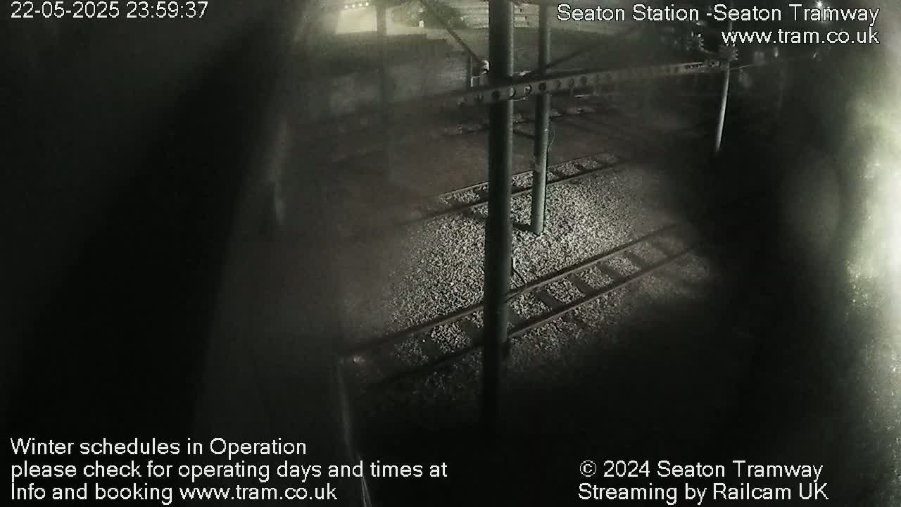 A nighttime, high-angle view of train tracks at a station.