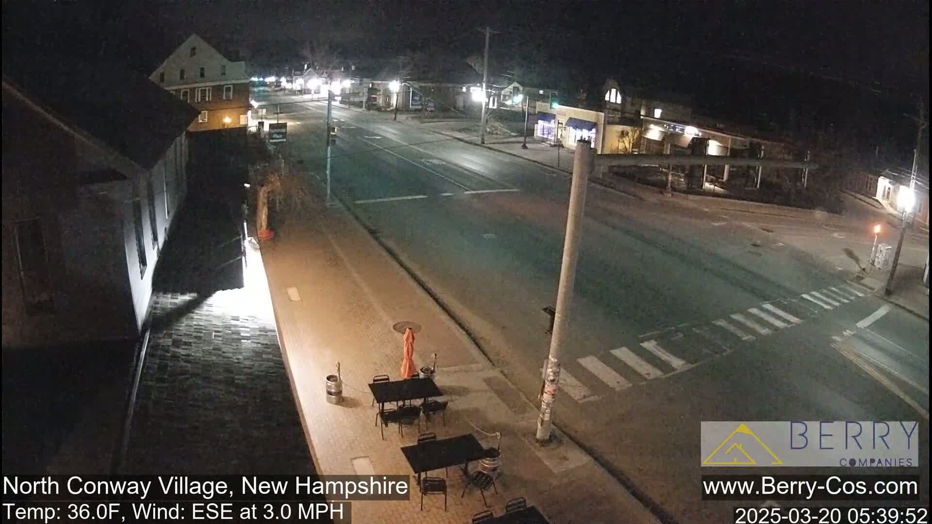 A nighttime street scene shows a mostly empty roadway with a few buildings visible, under clear skies and a 36°F temperature with a 3.0 mph ESE wind.
