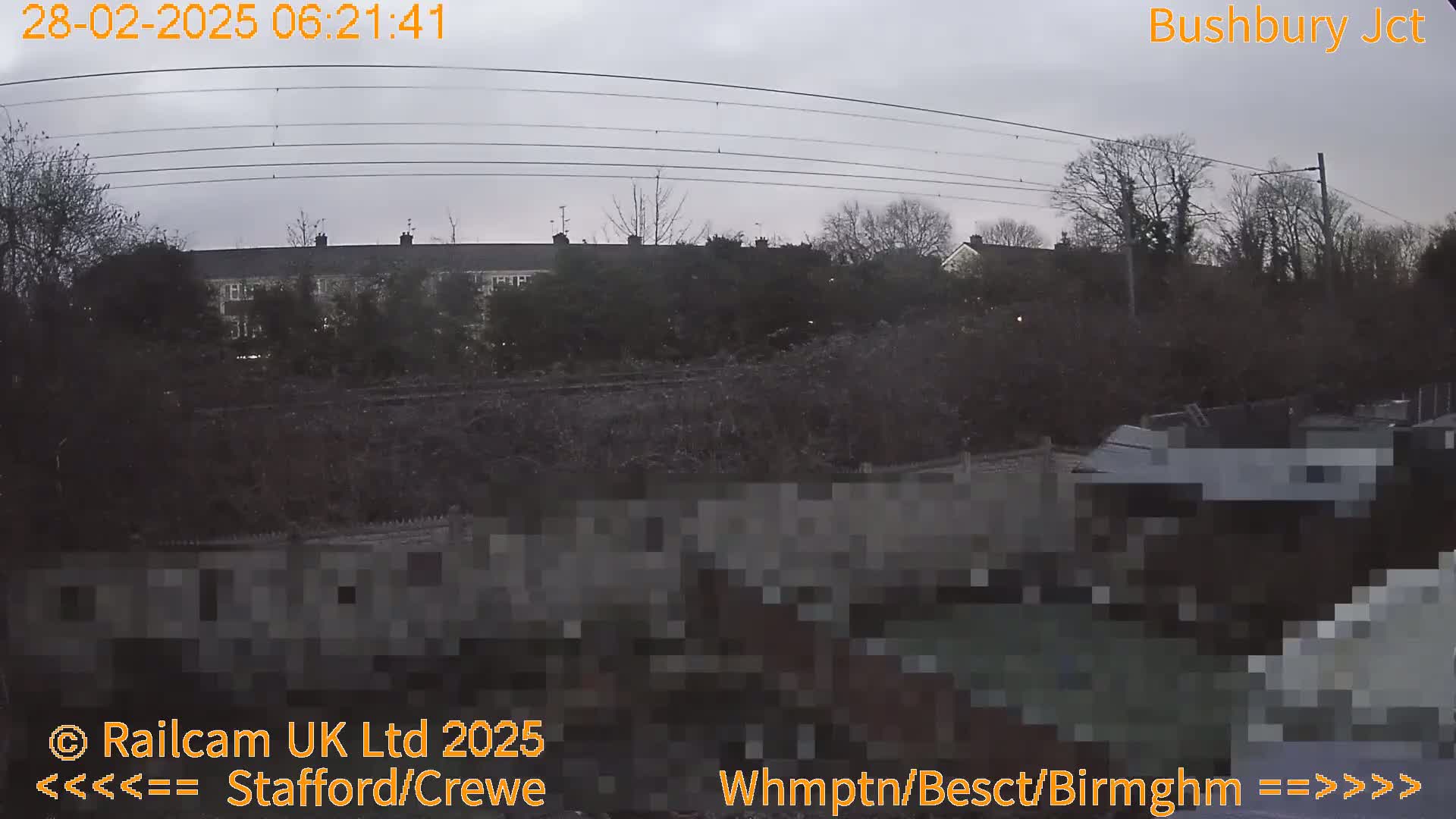 A view of a residential area and railway lines under an overcast sky.