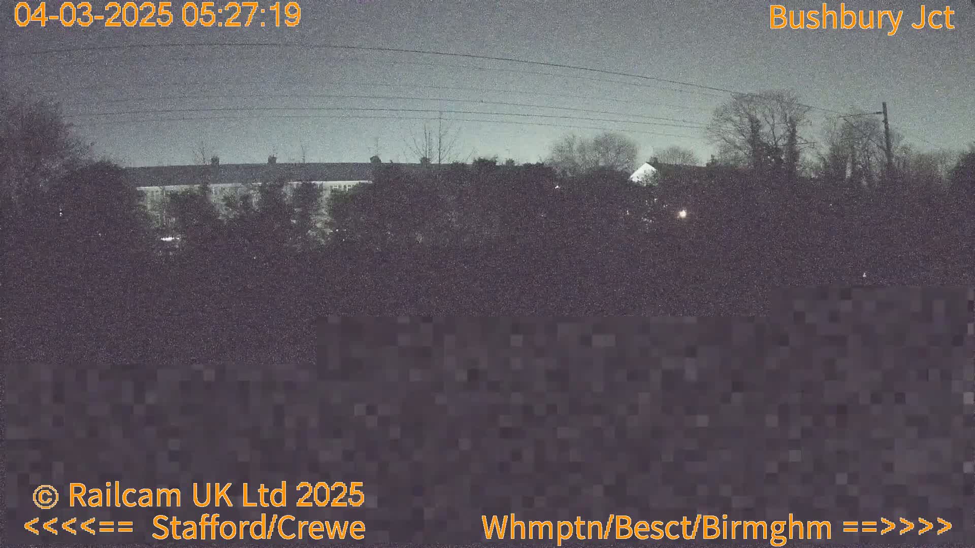 A nighttime, overcast view of houses and trees.