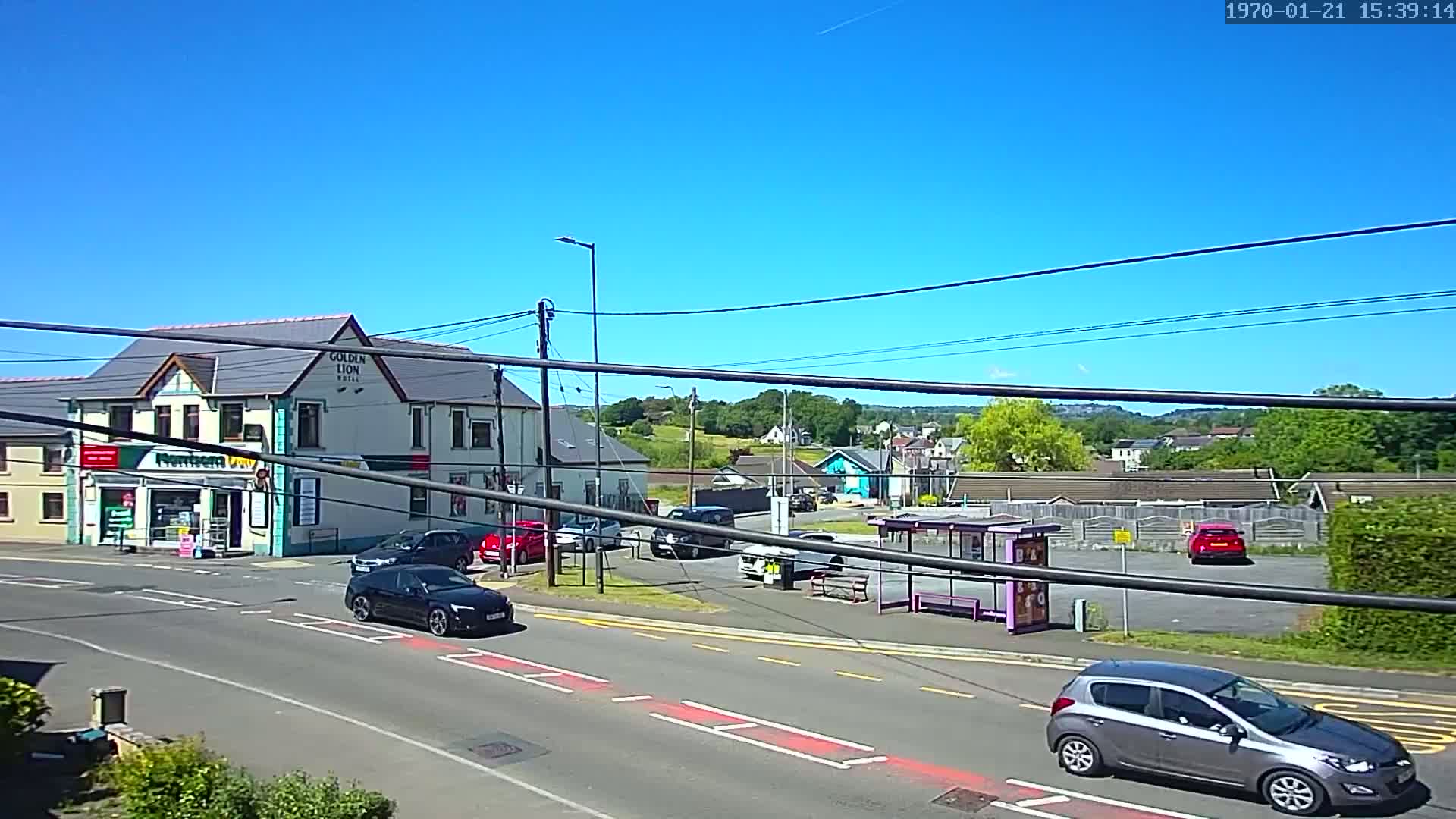A sunny day shows a street scene with cars, a bus stop, and a building labeled "Golden Lion Hotel."