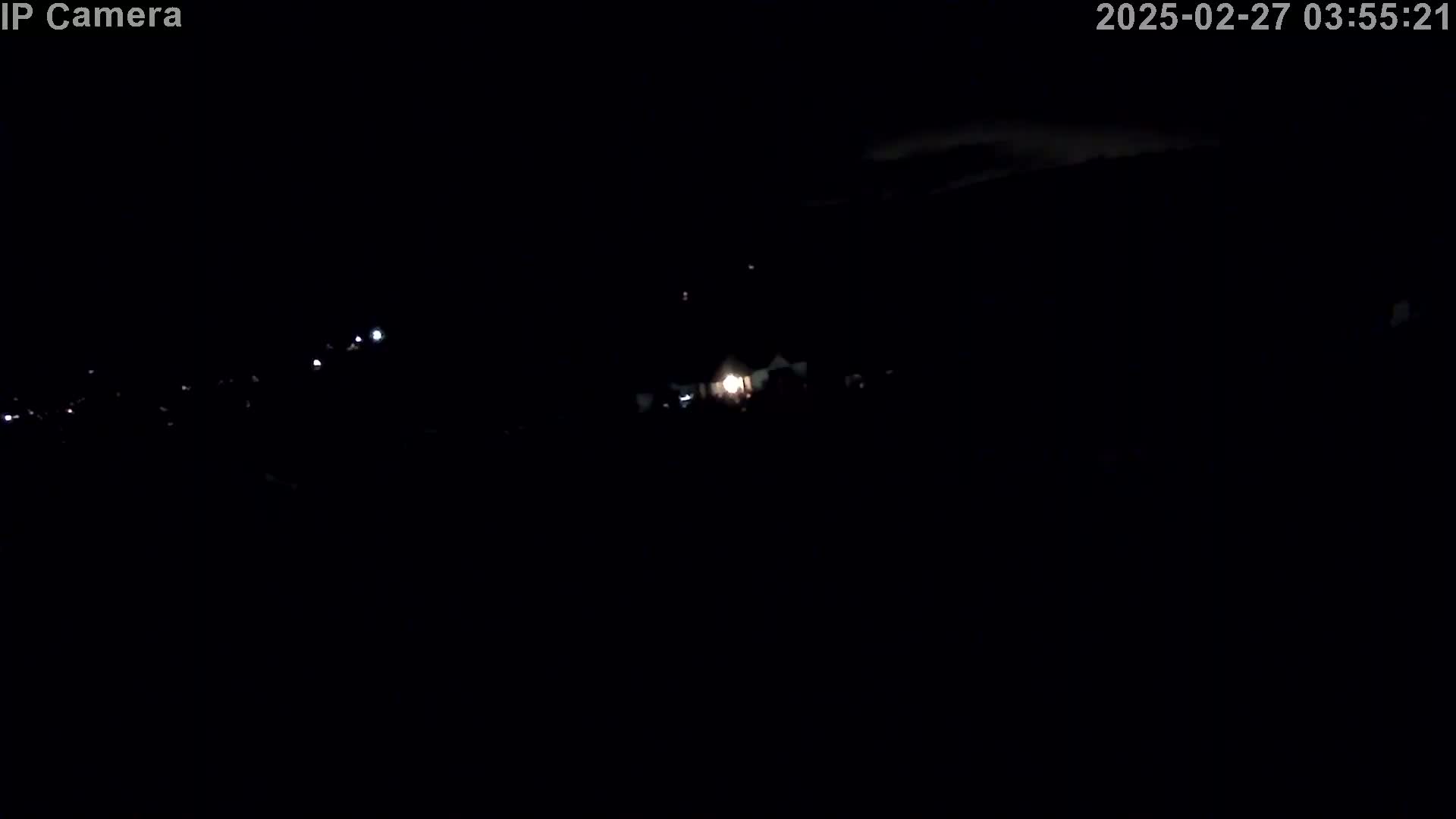 A nighttime, outdoor scene shows a few distant lights in the darkness.