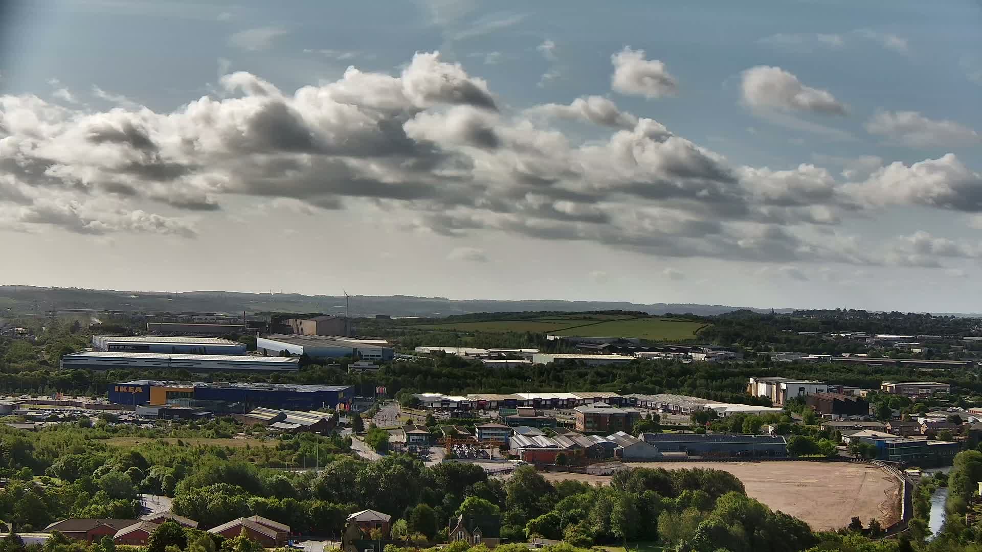 A sprawling industrial park and residential area under a partly cloudy sky.