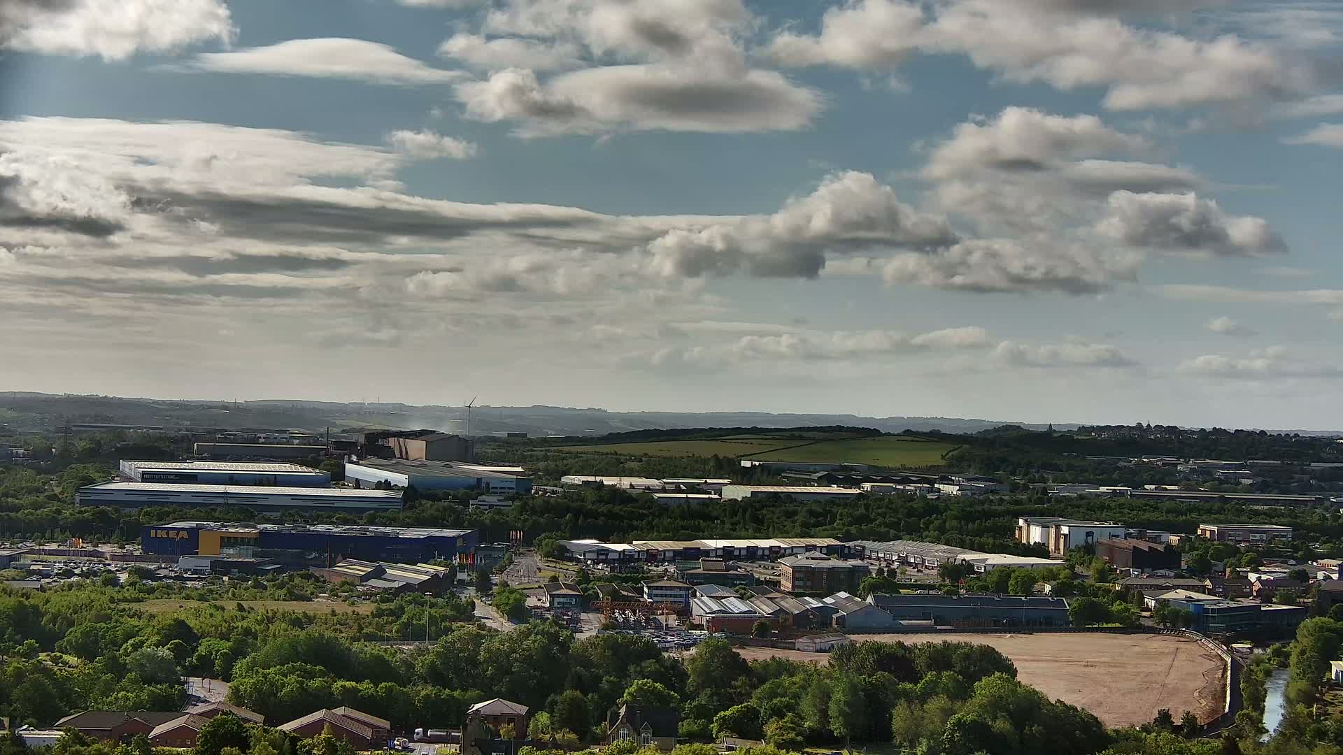A sprawling industrial and commercial area with an IKEA store is visible beneath a partly cloudy sky.