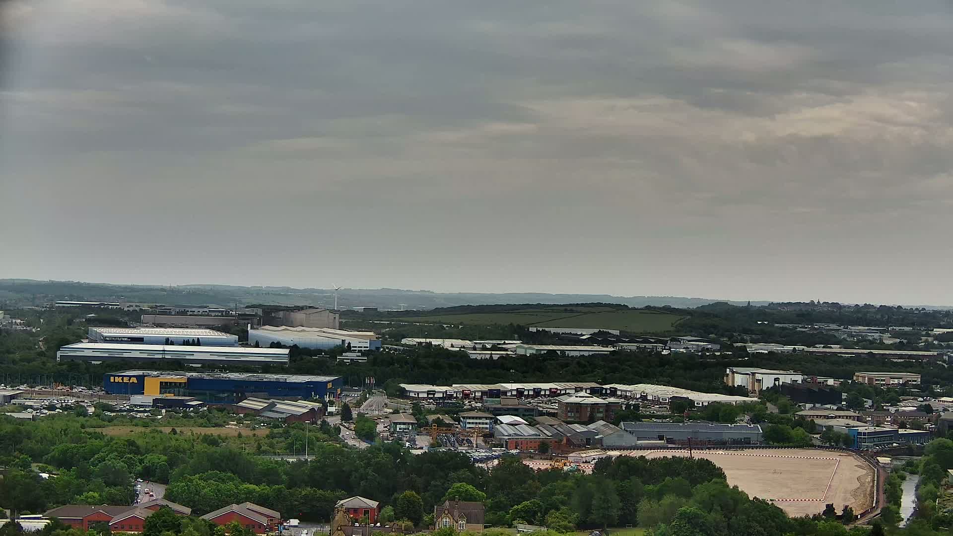 An aerial view of an industrial area with an IKEA store, under an overcast sky.