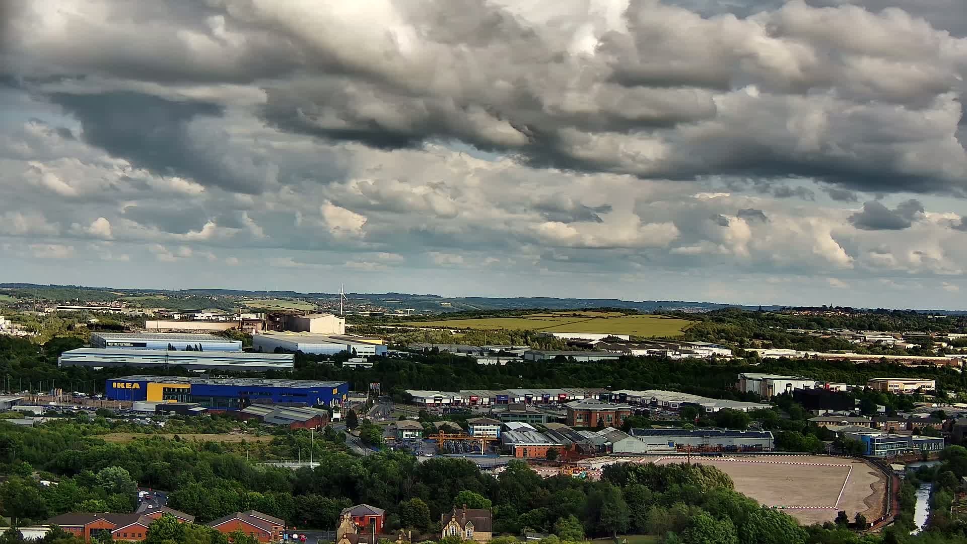 A sprawling industrial and residential area under a heavily clouded sky.