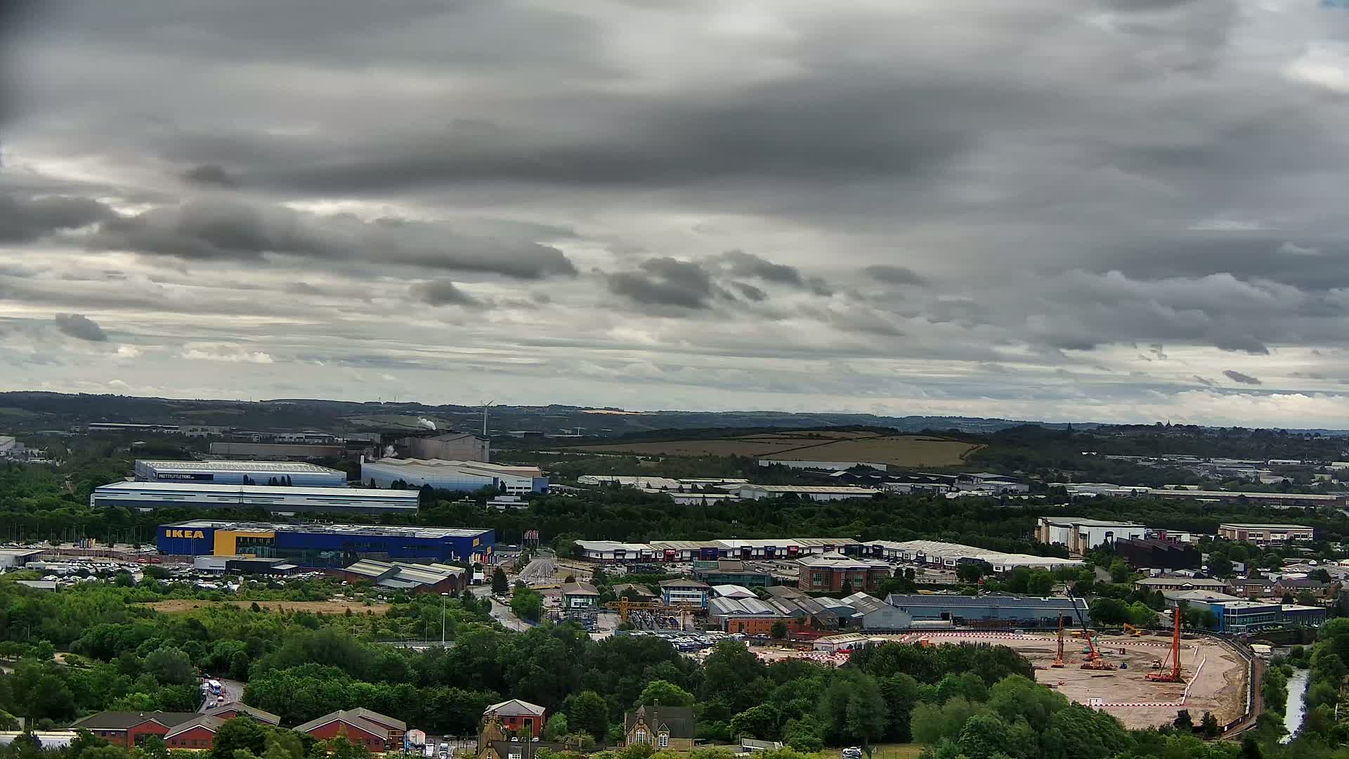 A sprawling industrial park and retail area, including an IKEA, is visible beneath a cloudy sky.