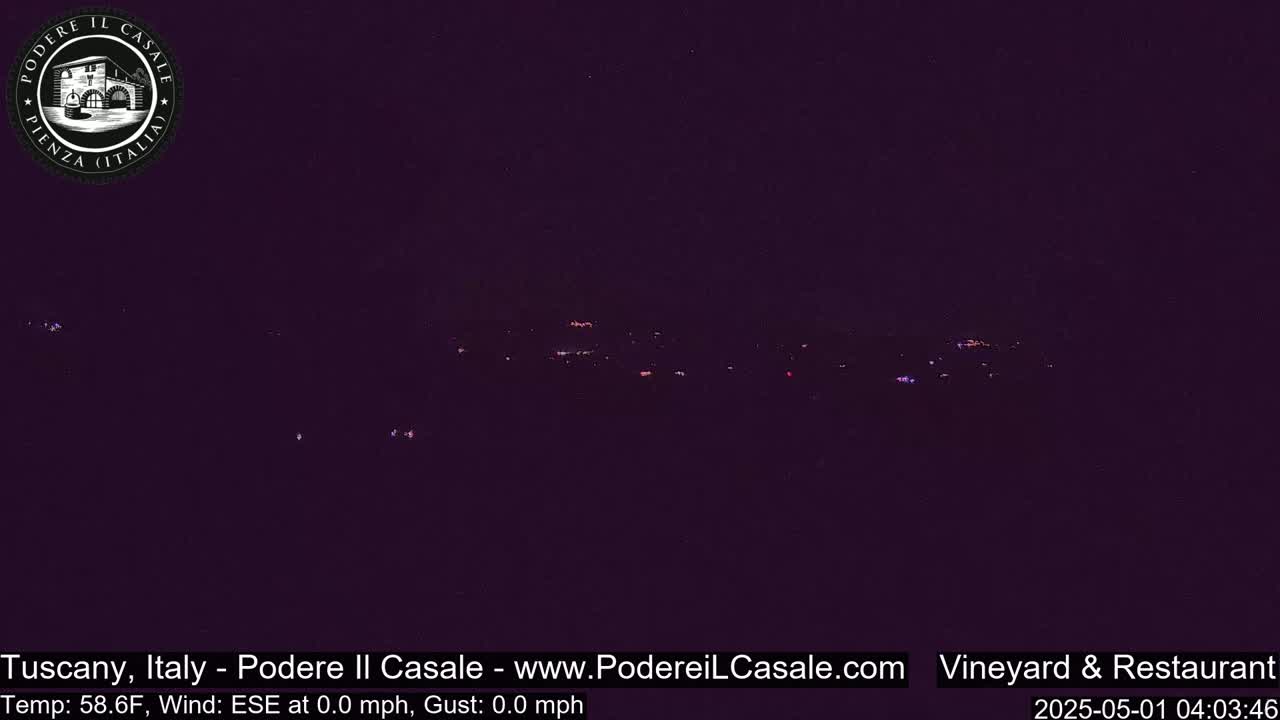 A nighttime, low-light view of a distant, dimly lit landscape with calm weather conditions.