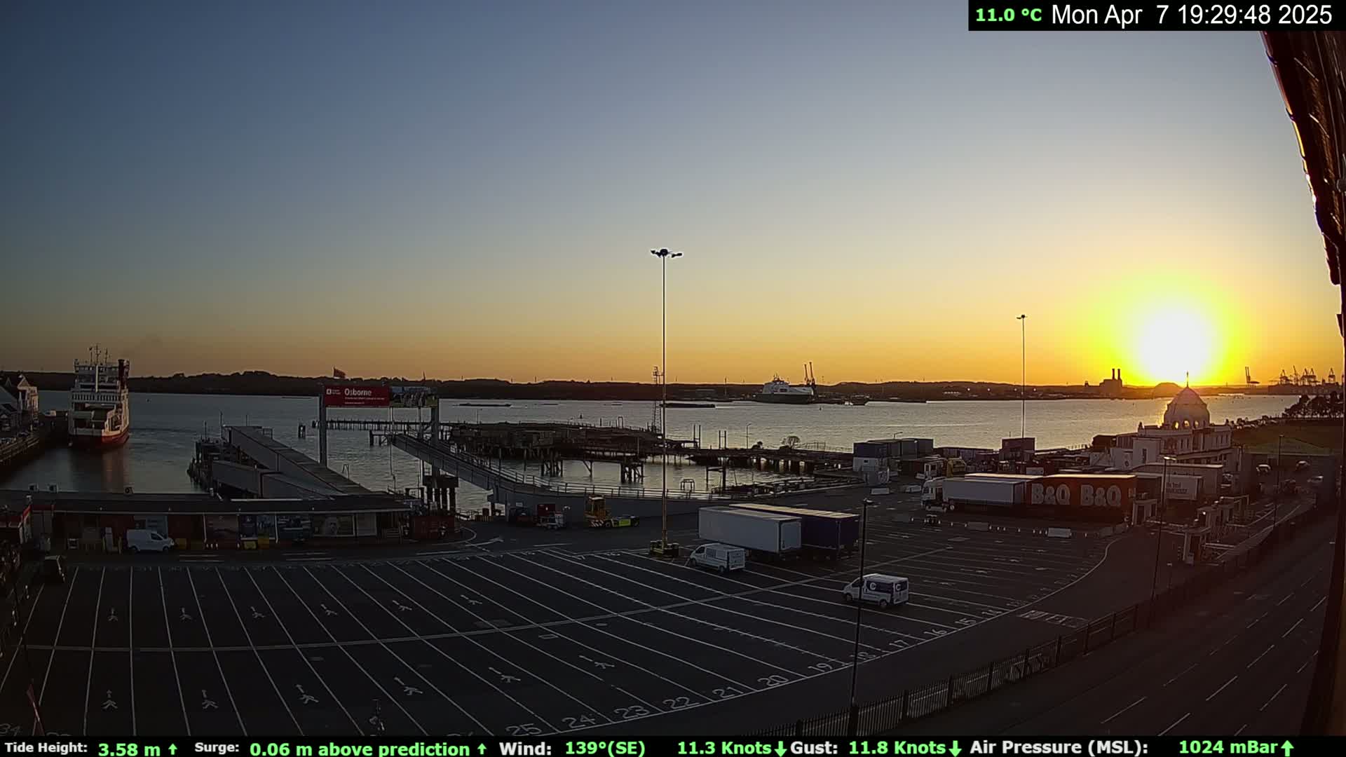 A ferry terminal at sunset, with a calm body of water and clear skies.