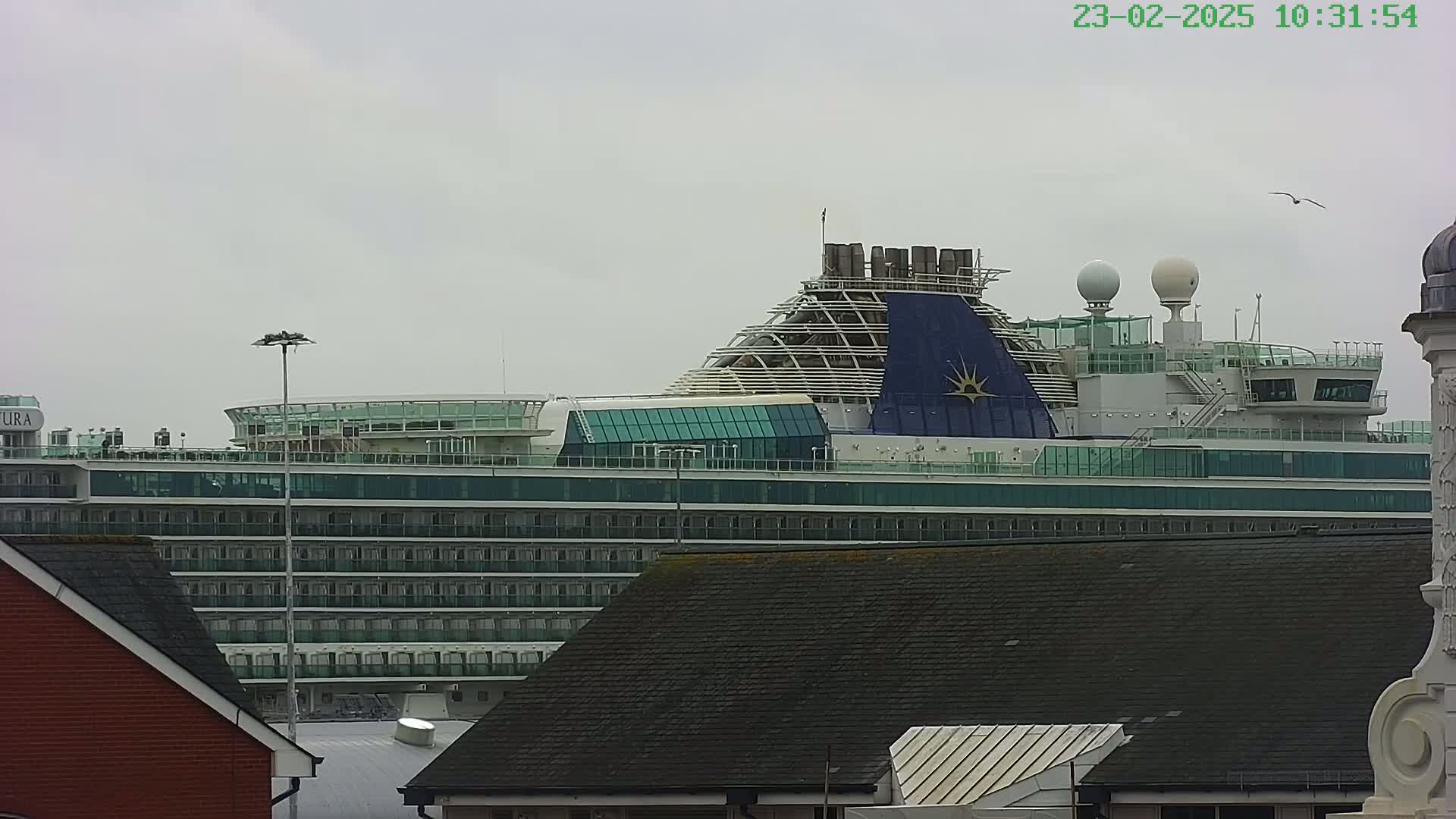 A large cruise ship is docked under an overcast sky.