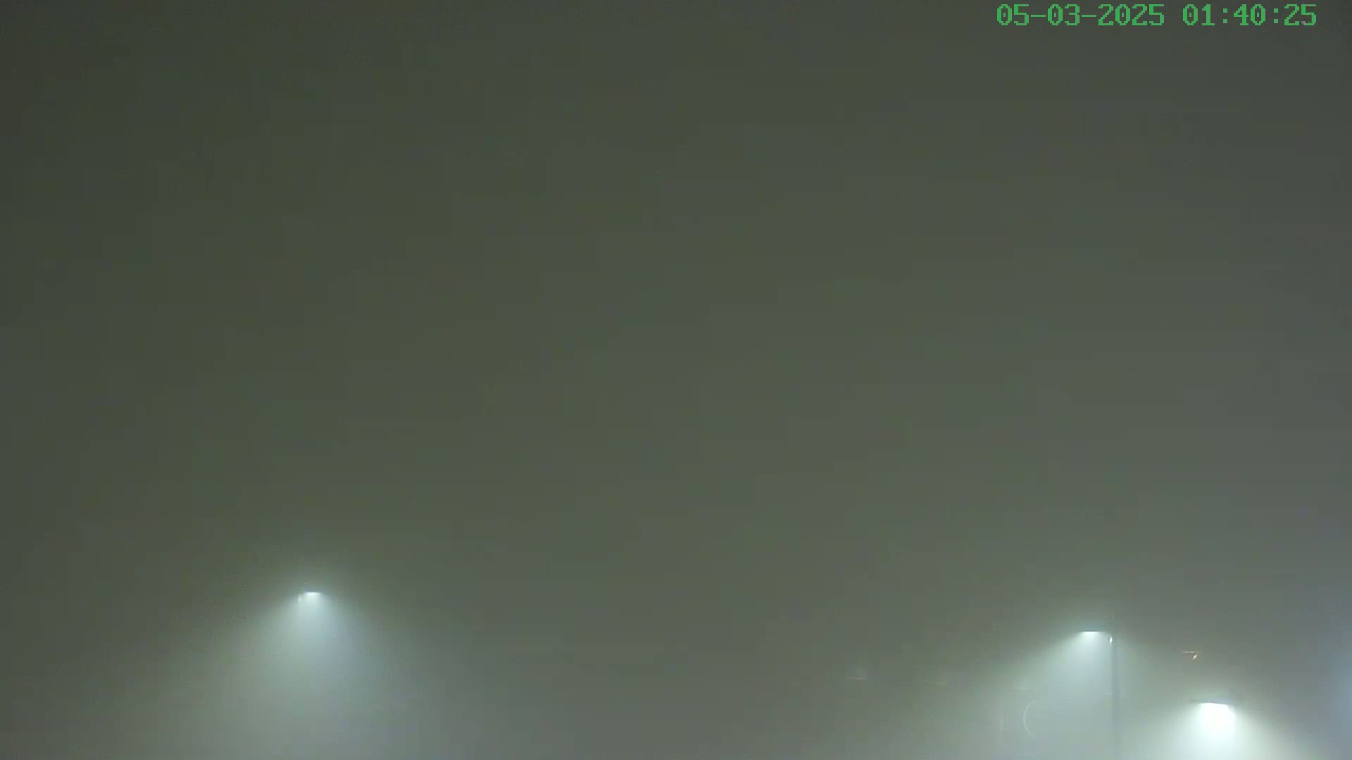 Three lights shine through a thick fog.