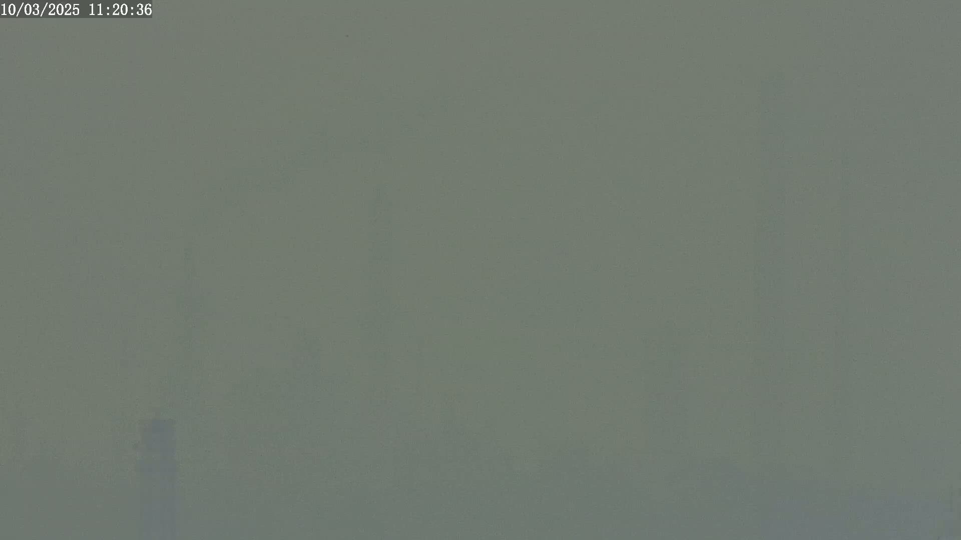 A hazy, muted grey scene is visible, with a barely perceptible object in the lower center.