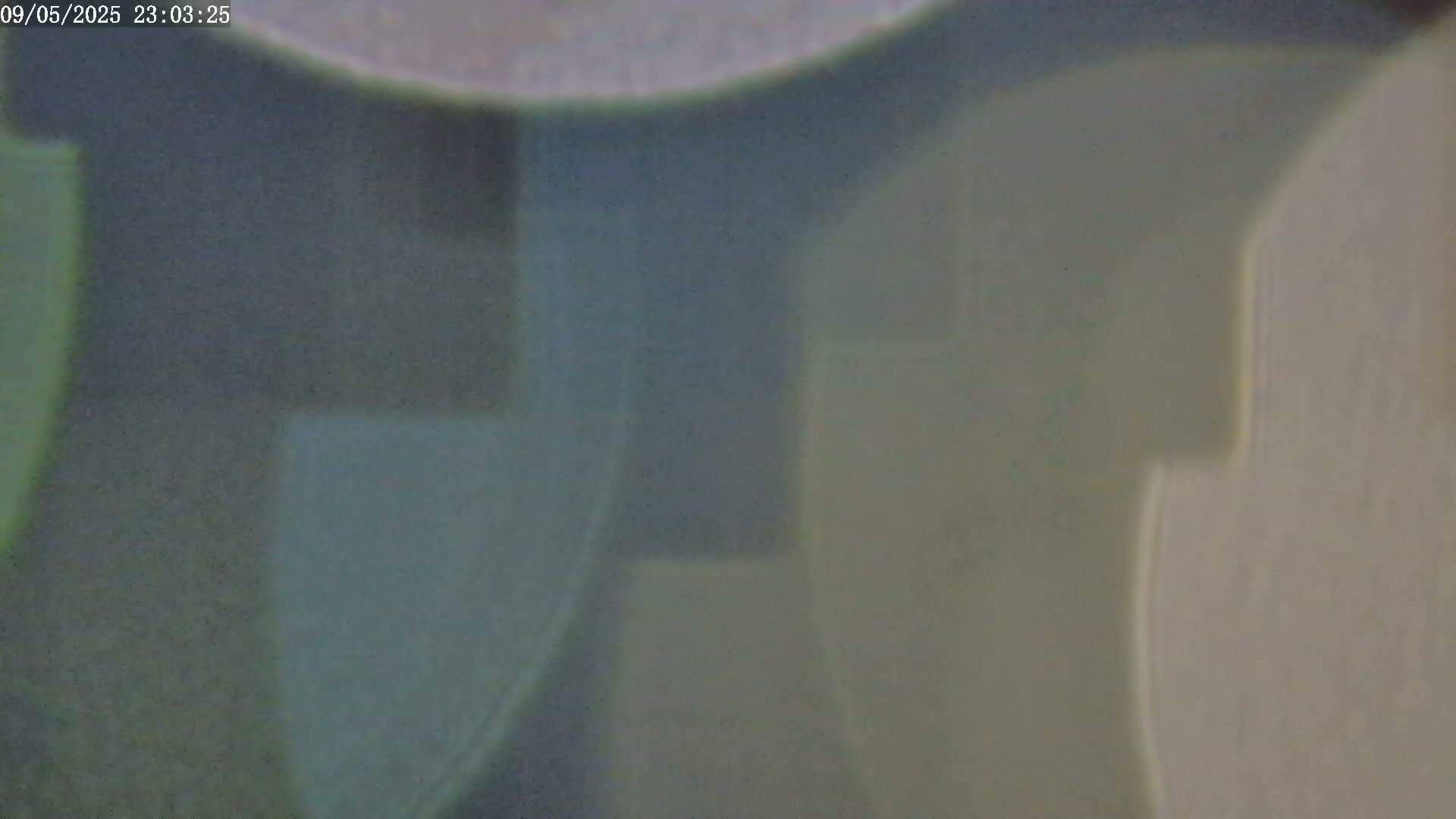 An out-of-focus image shows blurry, muted green and gray shapes resembling shadows or reflections.