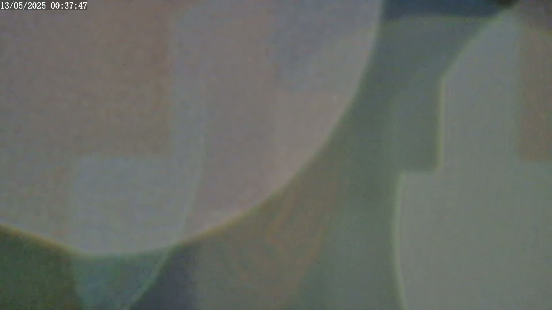 An out-of-focus image shows blurry muted pastel shapes and colors, predominantly pale greens and grays.