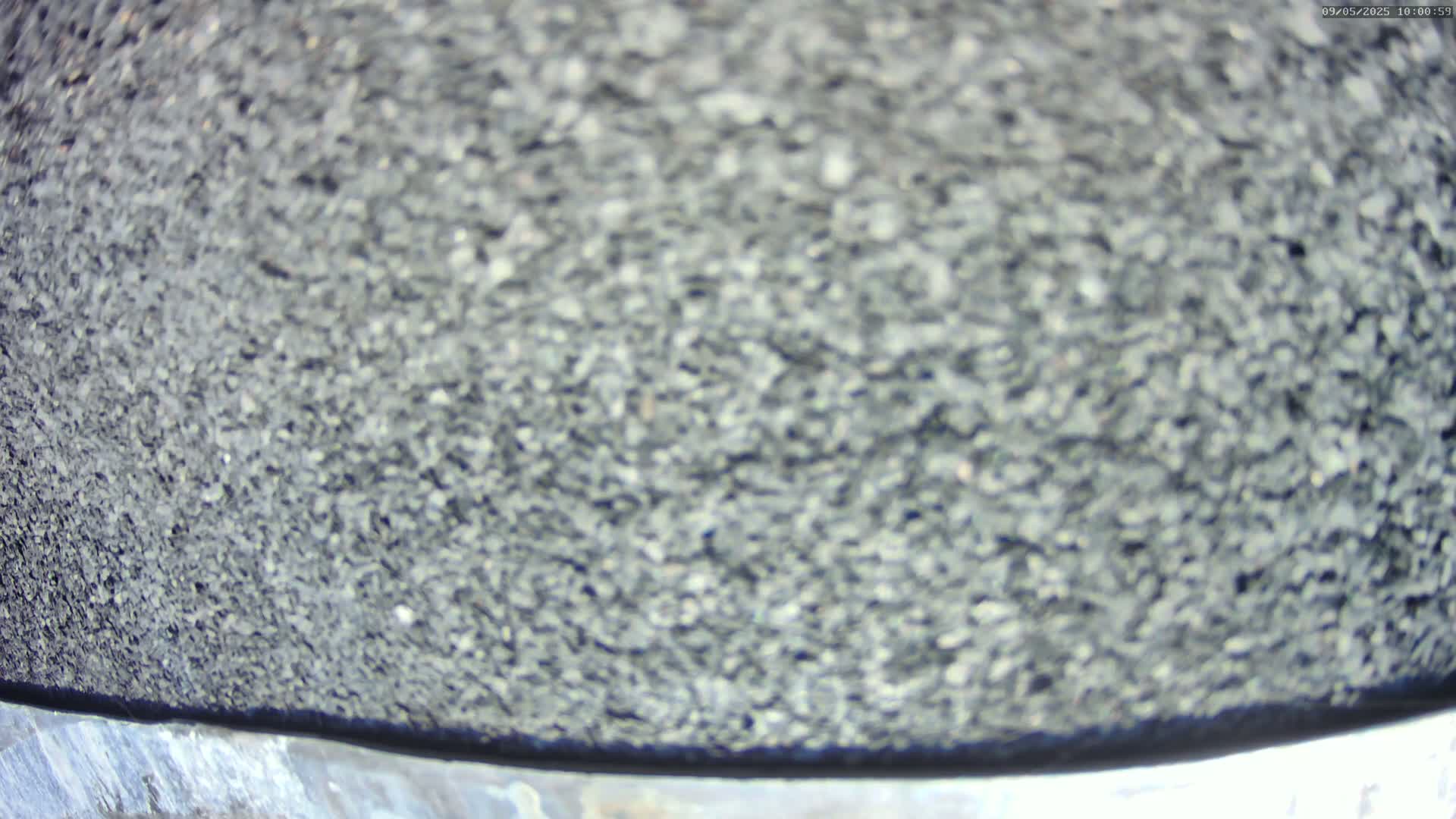 A blurry close-up shows a dark gray, granular surface.