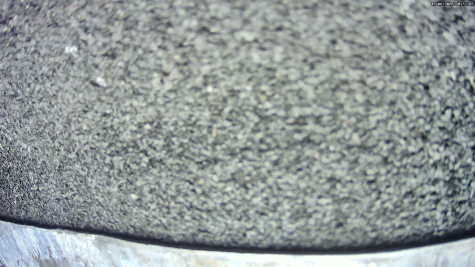 A blurry close-up shows a dark gray, granular surface.