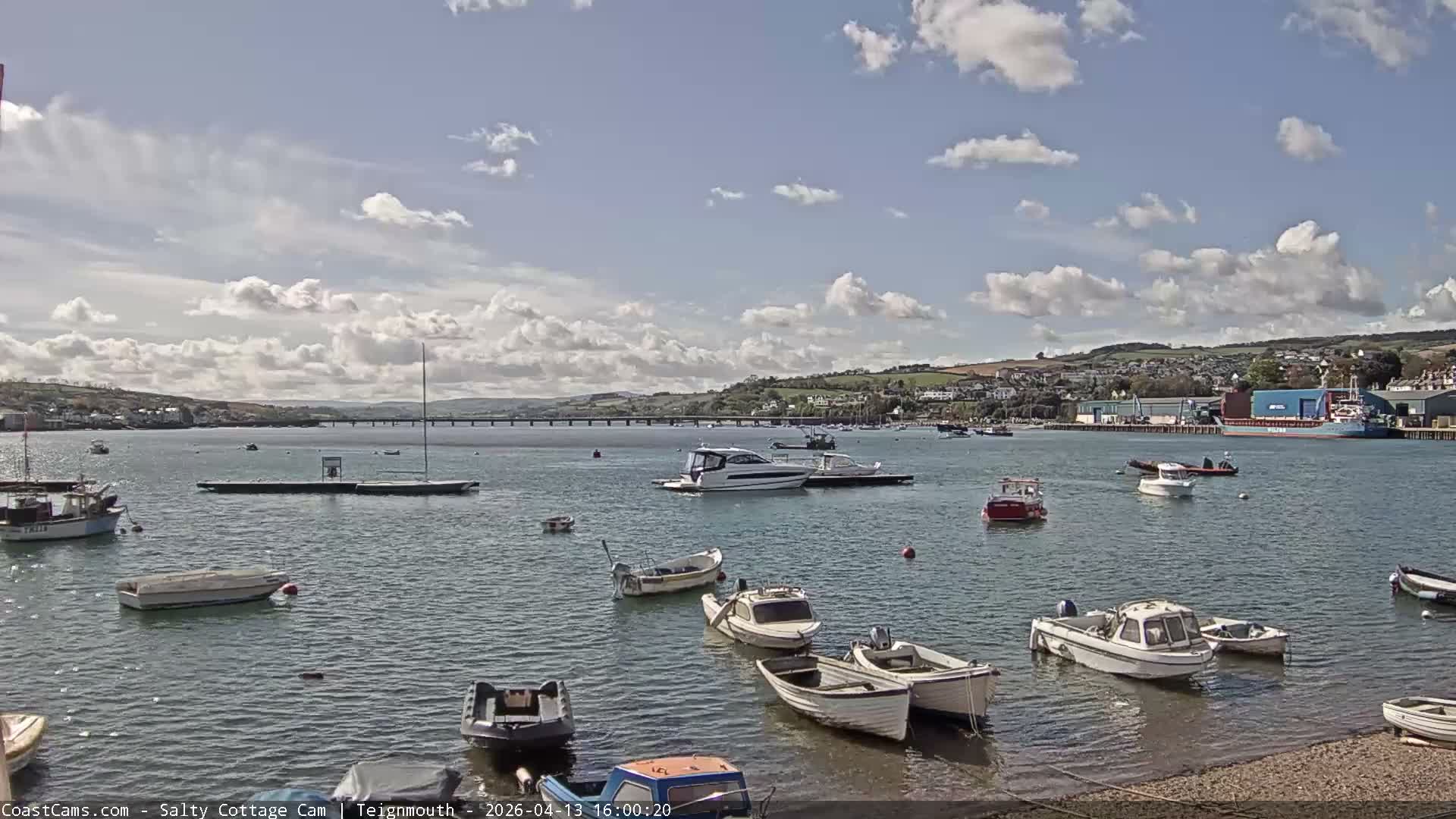 A calm harbor with numerous small boats and sailboats, under an overcast sky.