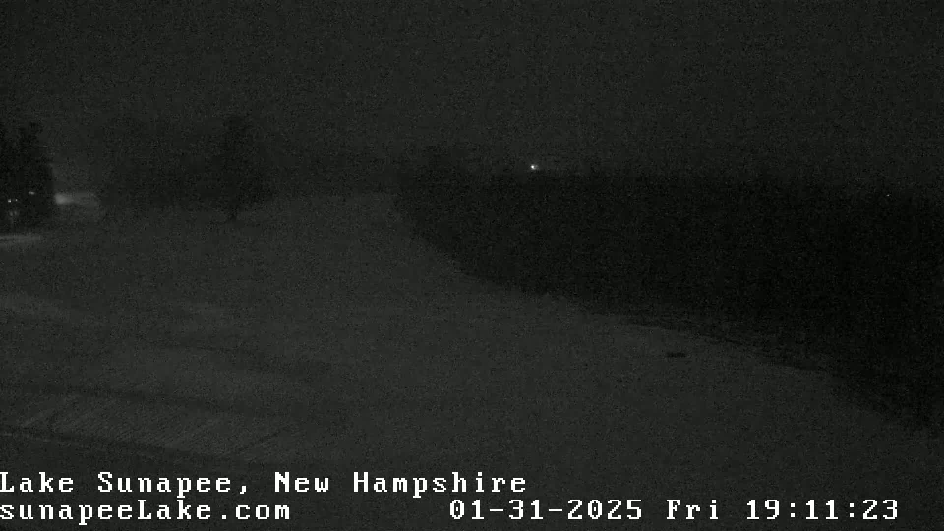 A nighttime, snow-covered landscape is visible, with a few distant lights.