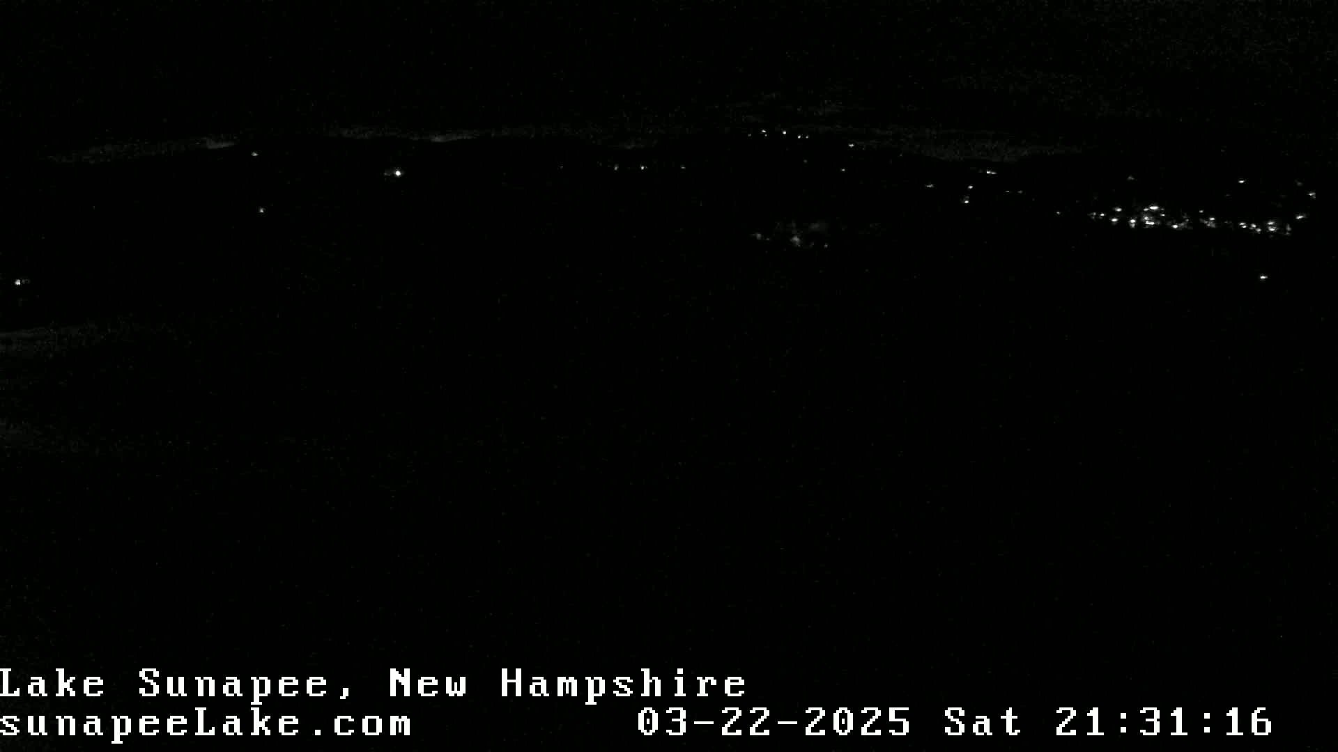 A nighttime long shot shows a distant line of faint lights across a dark landscape.
