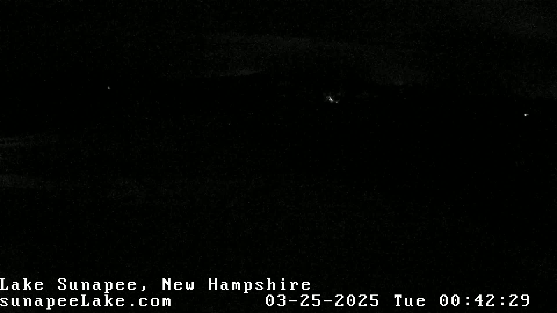A nighttime, dark image shows a very dimly lit landscape.