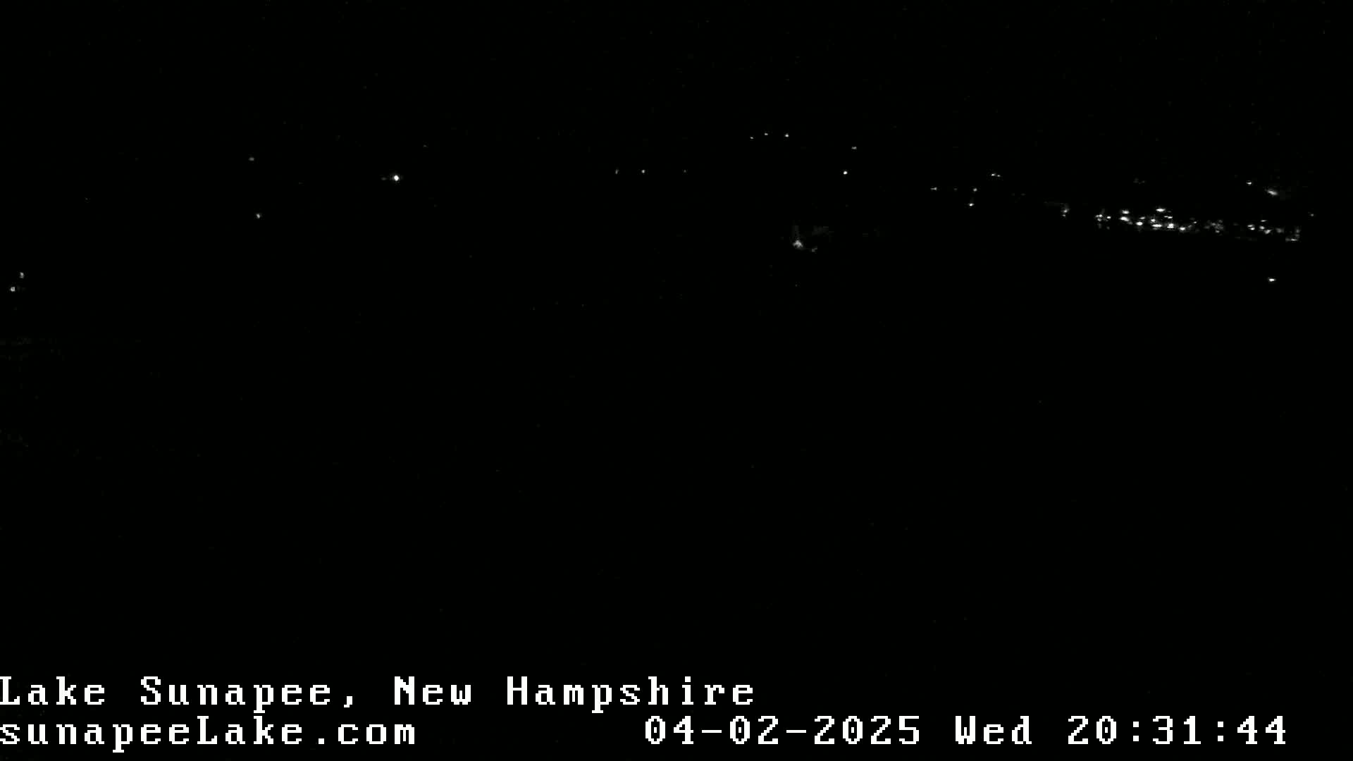 A nighttime long shot shows a dark landscape with a faint, distant line of lights.