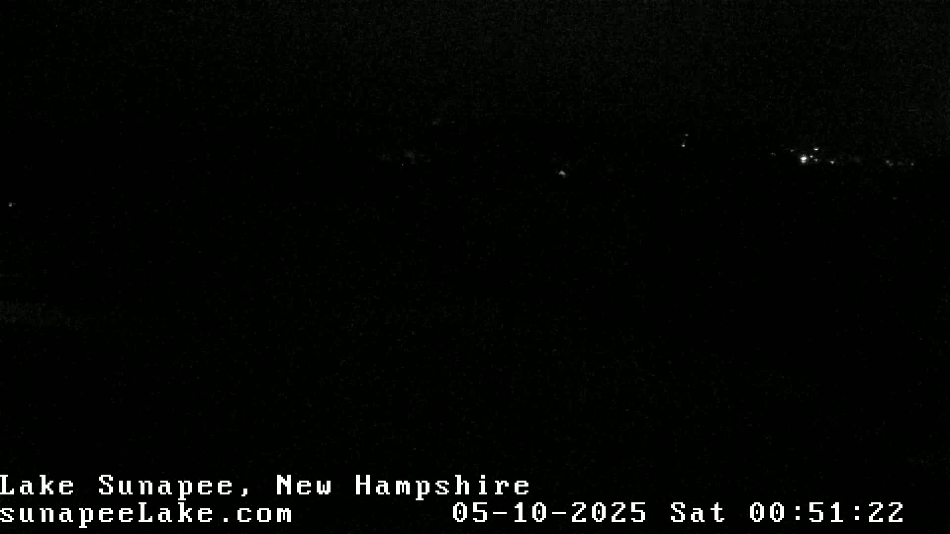 A nighttime long shot shows a dark landscape with a few distant lights.