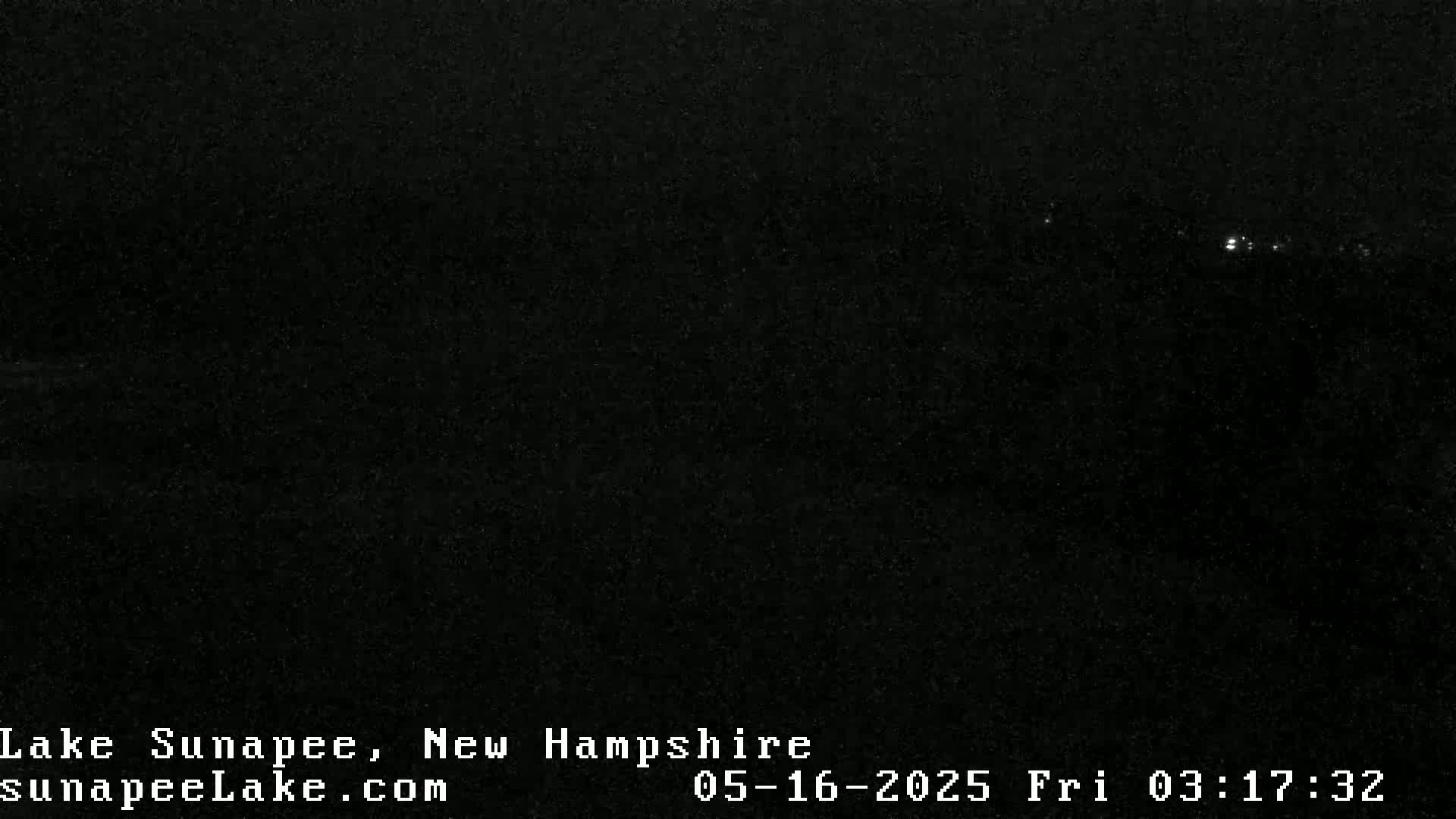 A nighttime long shot shows a dark, mostly featureless landscape with a few distant, faint lights.