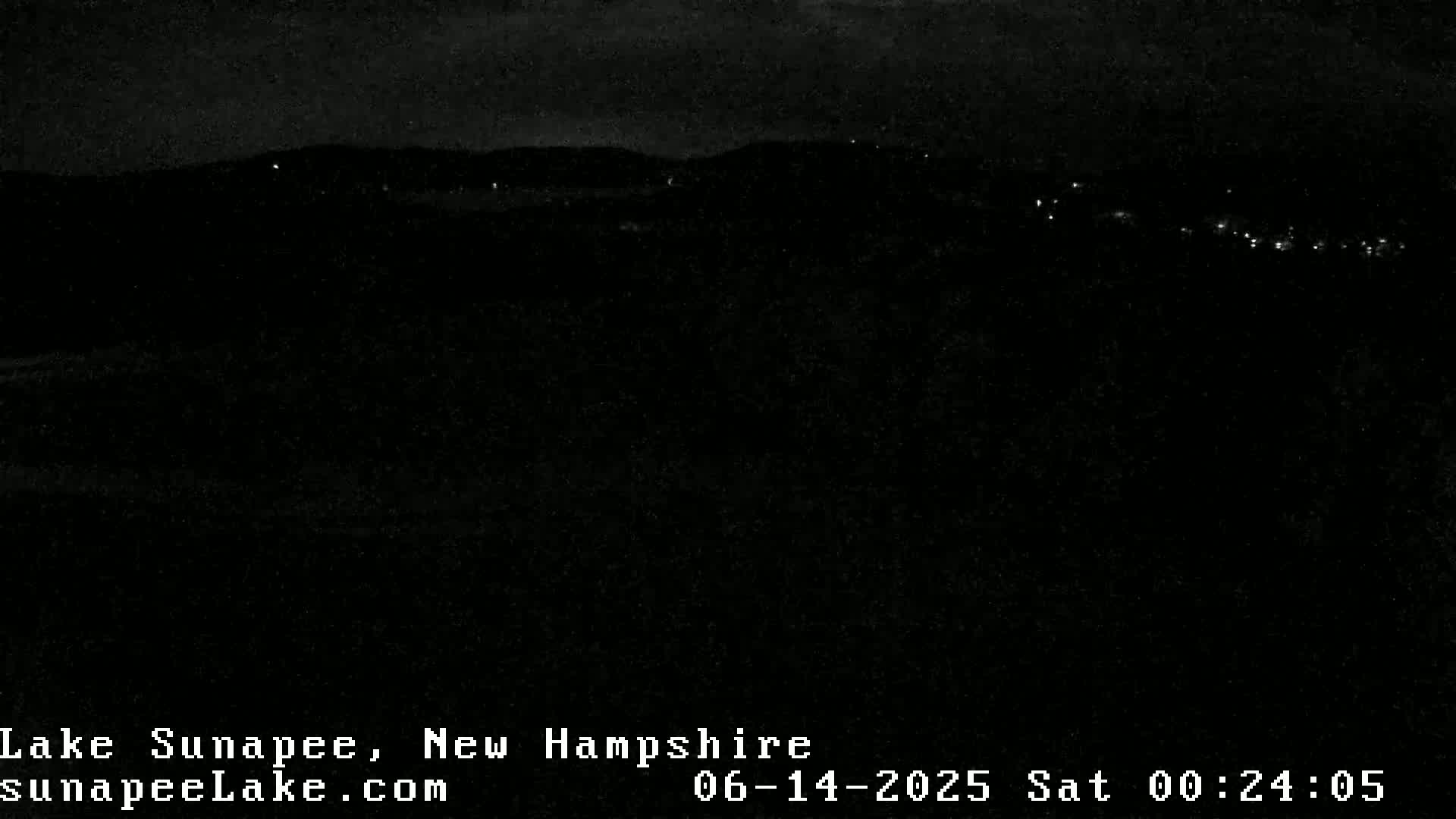 A nighttime long shot shows a dark landscape with a few distant lights.