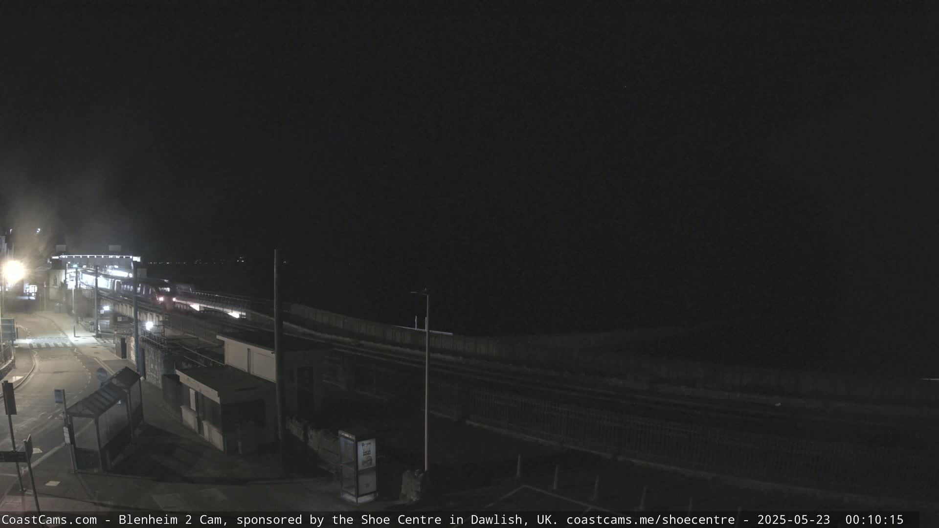 A nighttime, dimly lit train passes through a station.