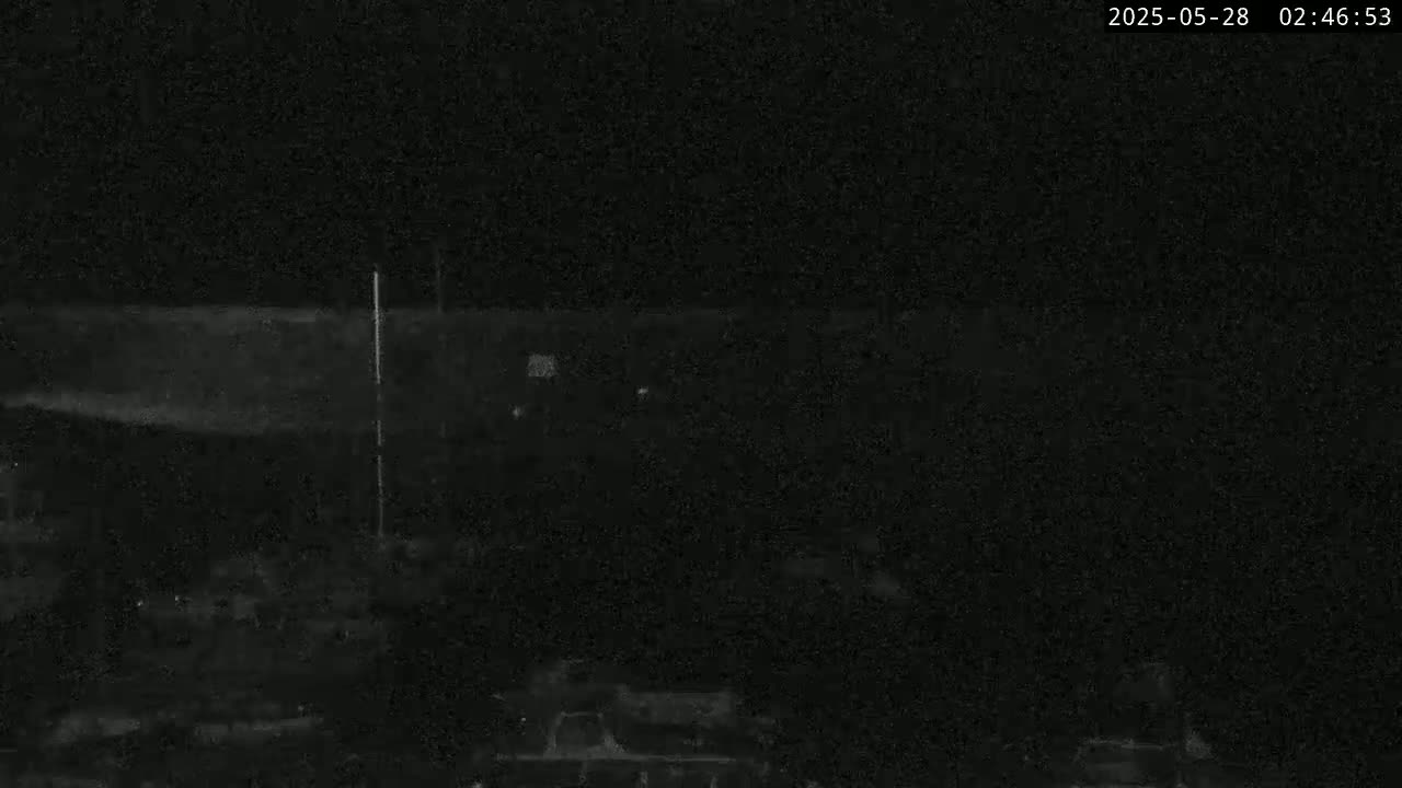 A dark, nighttime image shows a low-light view of an indistinct, possibly outdoor scene with a very low light level.