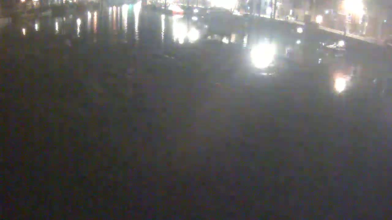 A nighttime view of dark water reflecting city lights.