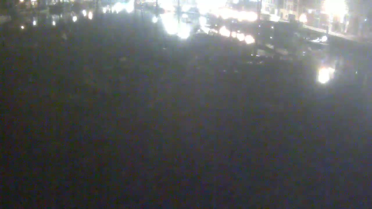 A nighttime, blurry view of a dark body of water reflecting city lights.