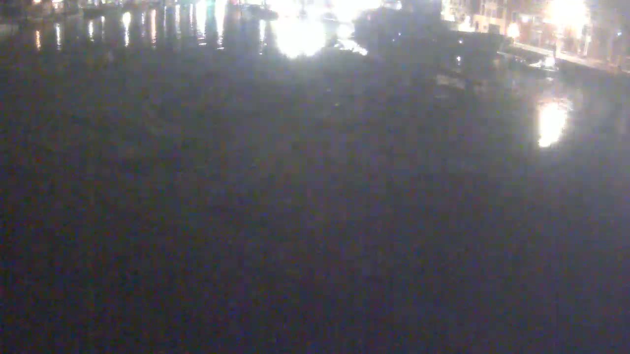A nighttime view of dark water reflecting city lights.
