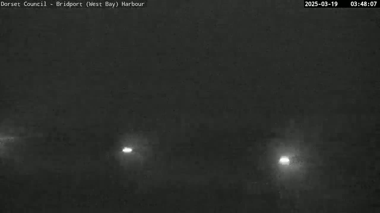 Three faint lights are visible through a dark, foggy atmosphere.