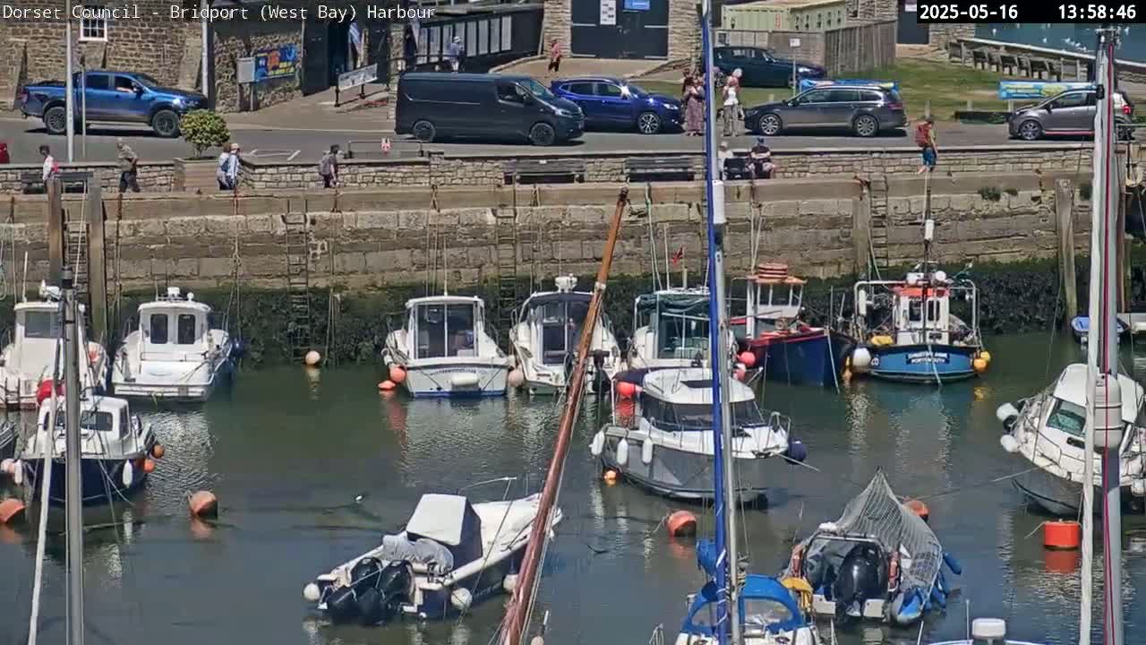 Several small boats are moored in a harbor on a sunny day.