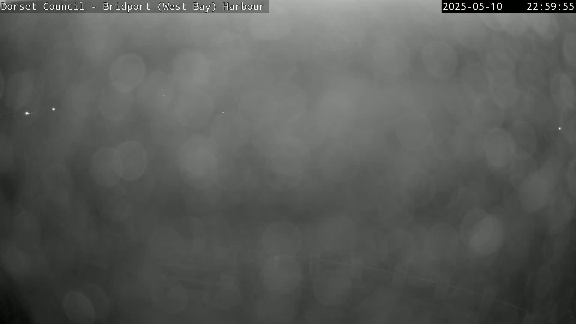 A blurry, dark gray image shows a hazy or foggy nighttime scene.