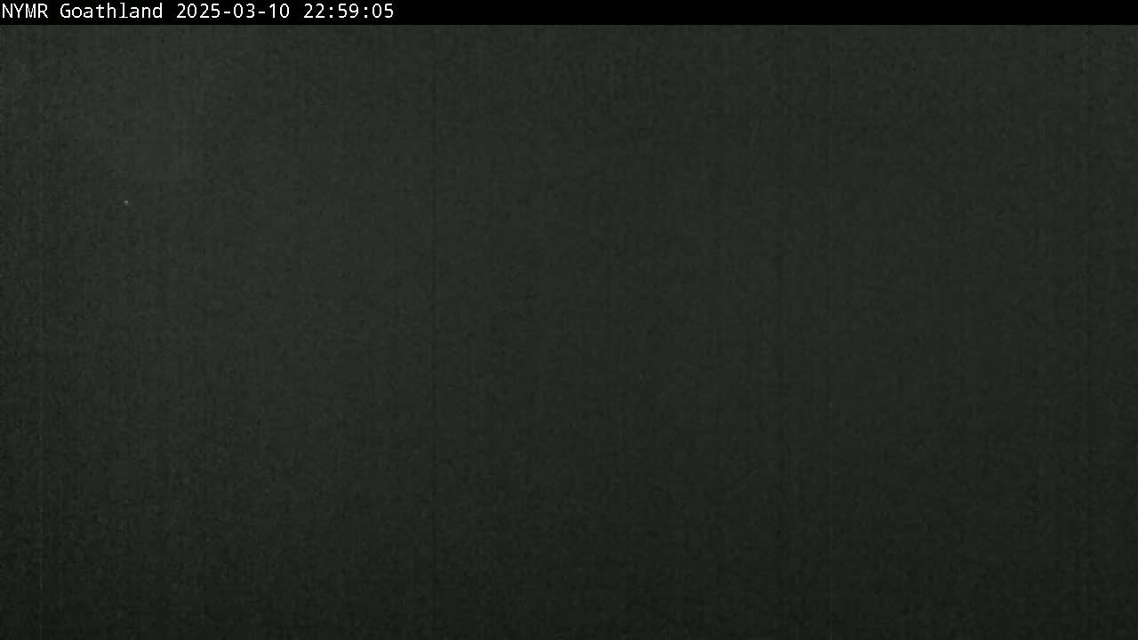 A dark, nighttime image shows a mostly uniform, dark-gray to black surface.