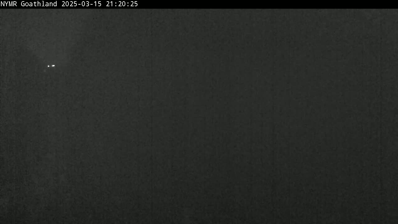A dark, nighttime image shows two small, distant lights in a mostly featureless, dark sky.