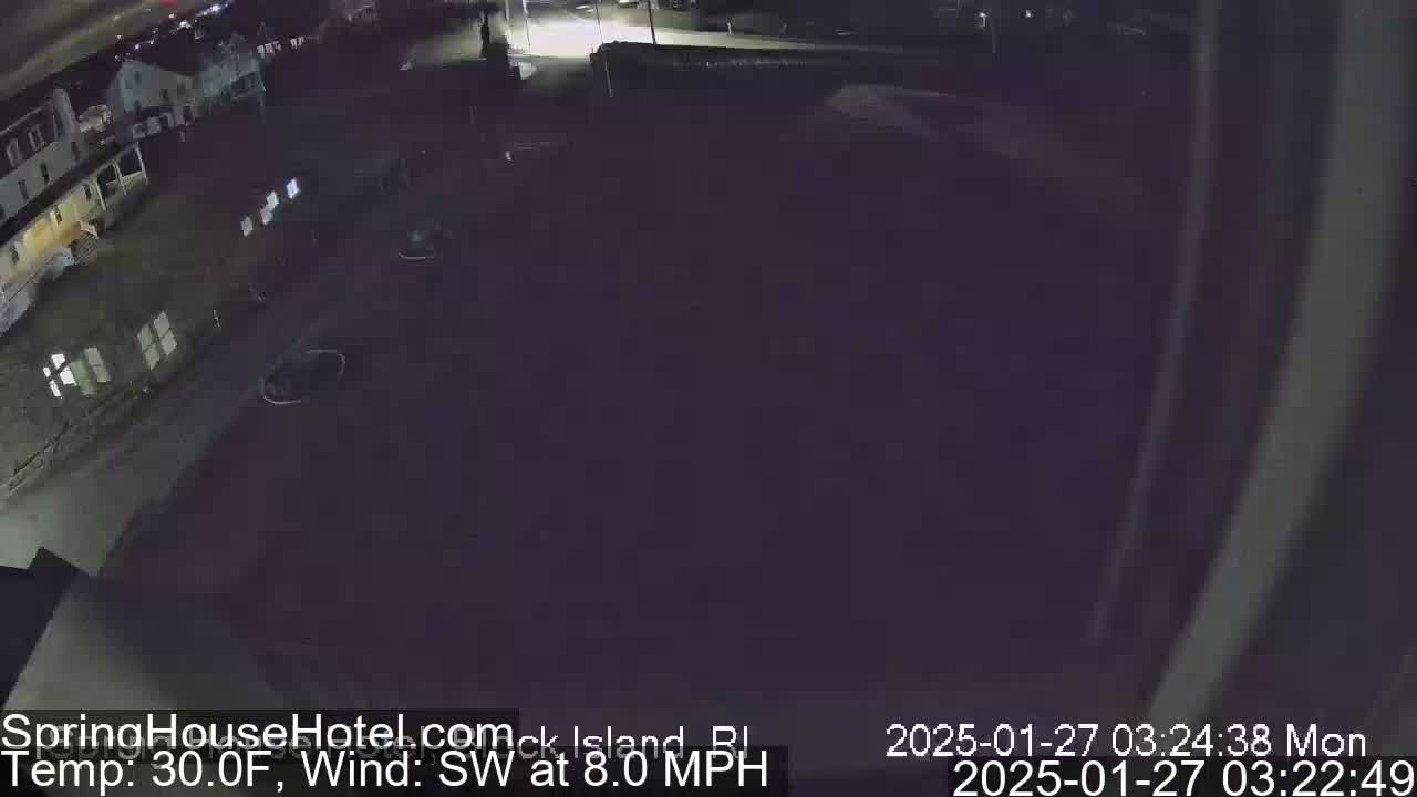 A nighttime, high-angle view of a dark parking lot next to buildings, with a southwest wind at 8 mph and a temperature of 30 degrees Fahrenheit.