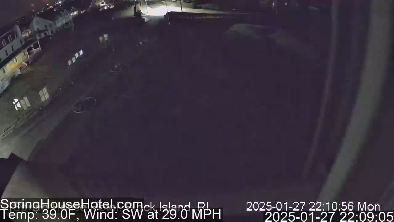 A nighttime, high-angle view of a dark, mostly empty parking lot next to buildings, with a southwest wind at 29 mph and a temperature of 39°F.