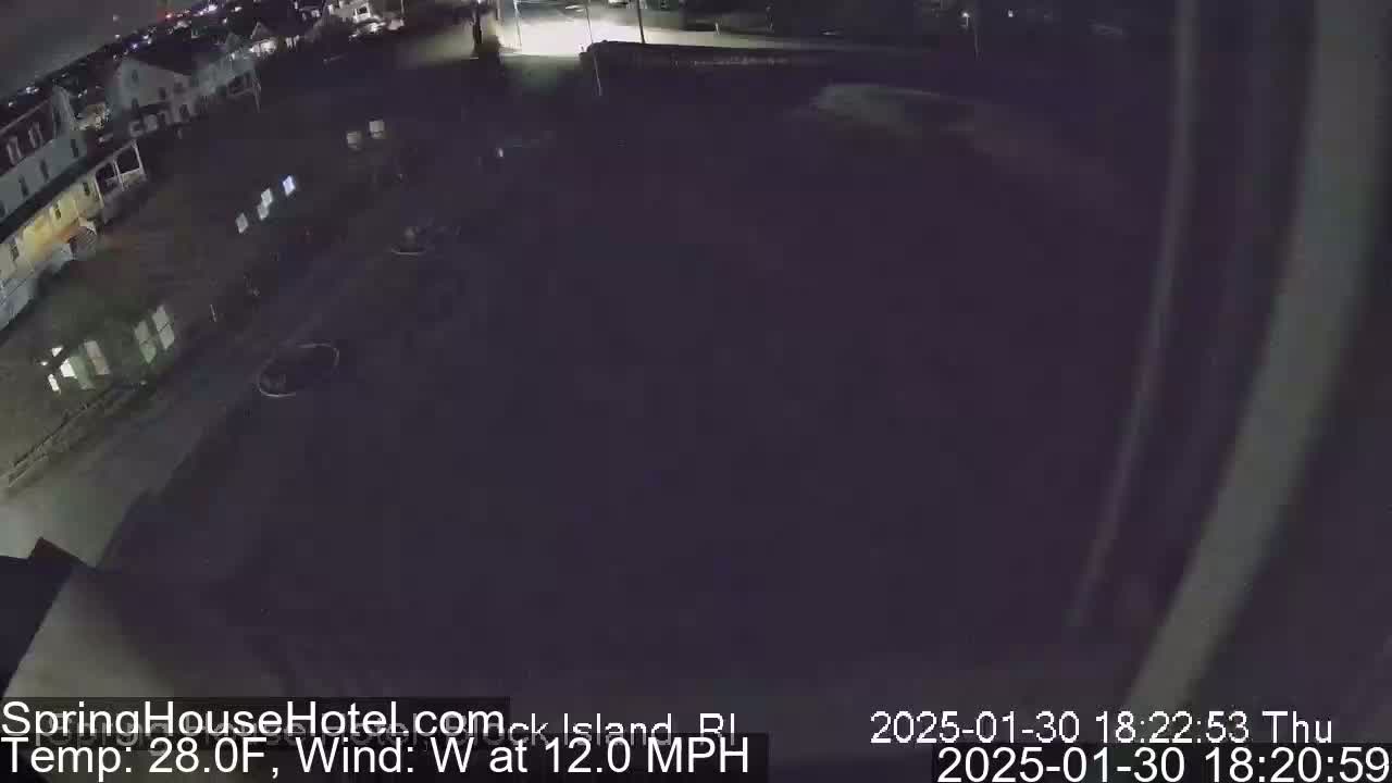A nighttime, overhead view of a mostly empty parking lot next to some buildings in 28-degree weather with a 12 mph west wind.
