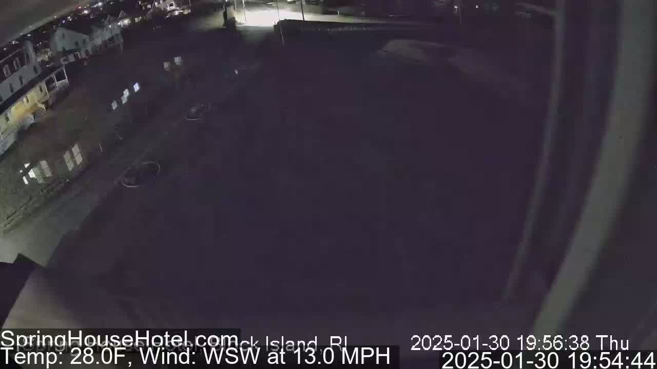 A nighttime, high-angle view of a parking lot and buildings, with a WSW wind at 13 mph and a temperature of 28 degrees Fahrenheit.
