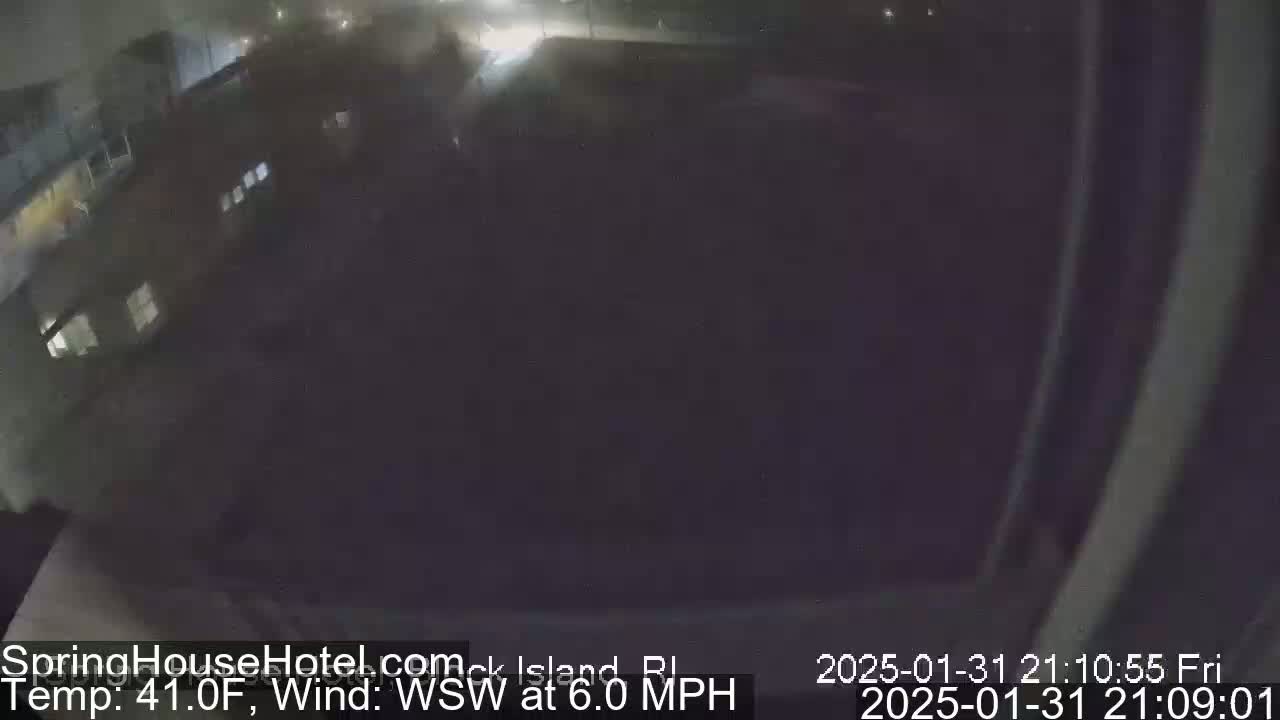 A nighttime, dimly lit outdoor scene shows a dark building and parking lot with a 41°F temperature and a 6.0 mph wind from the west-southwest.