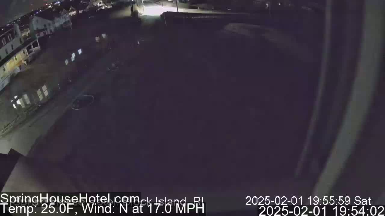 A nighttime, aerial view of a dark parking lot and buildings, with a north wind at 17 mph and a temperature of 25°F.