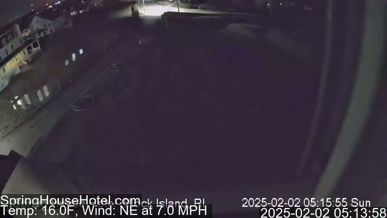 A nighttime, low-angle view of a dark street and buildings, with a northeast wind at 7 mph and a temperature of 16 degrees Fahrenheit.