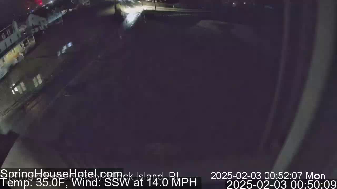 A nighttime, high-angle view of a flooded street and buildings under a dark sky with a south-southwest wind at 14 mph and a temperature of 35°F.