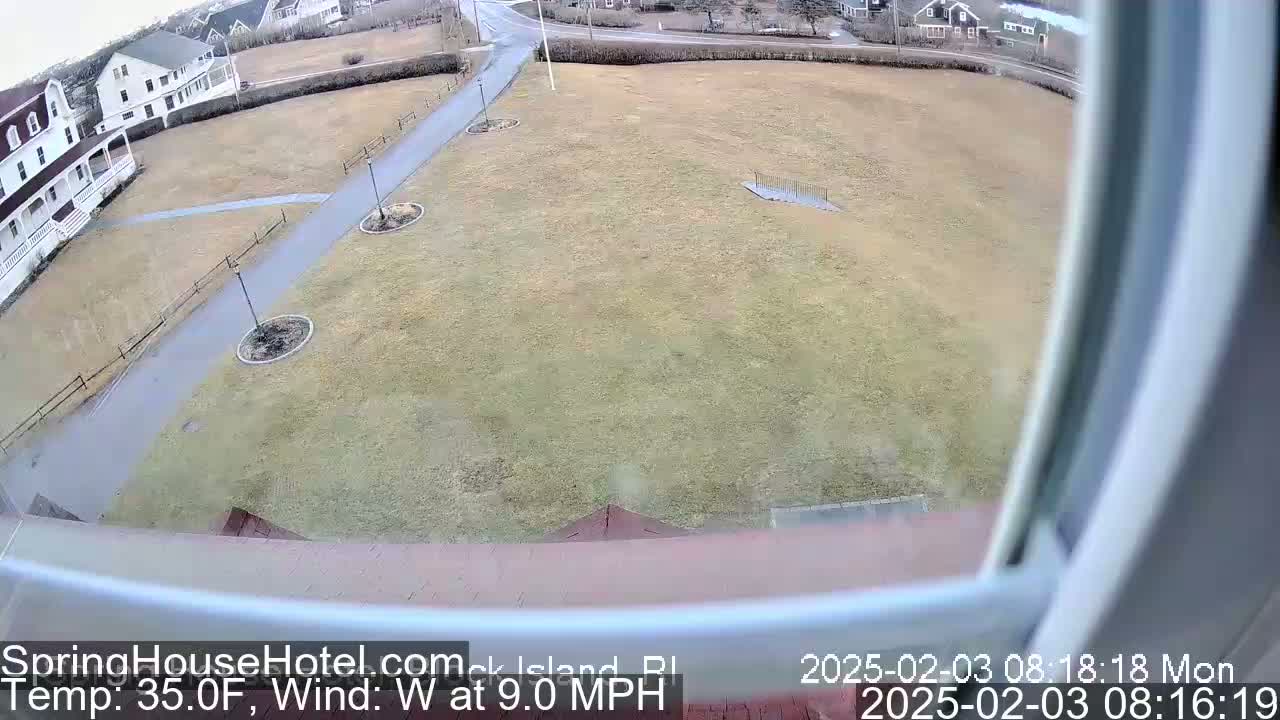 A wide outdoor shot from a window shows a grassy area with walkways, buildings in the background, and a 35°F temperature with a 9 mph west wind.
