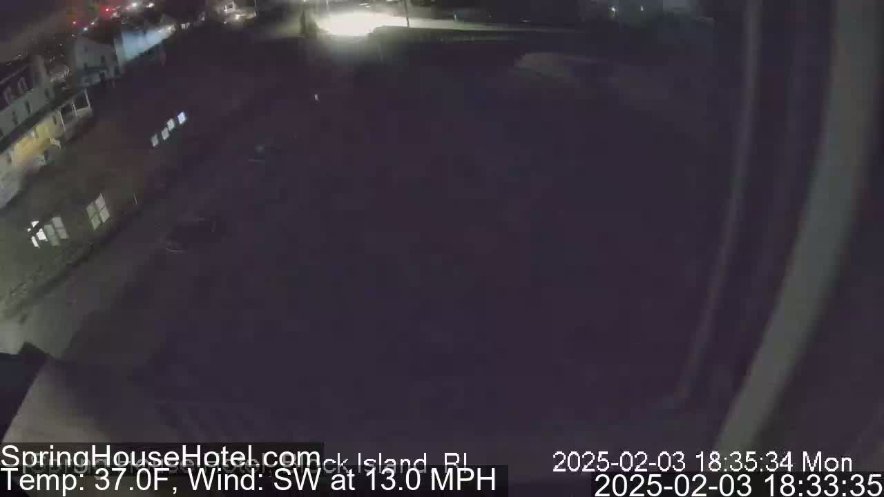 A nighttime, outdoor view of a dark parking lot next to a building under a dark sky with a southwest wind at 13 mph and a temperature of 37°F.