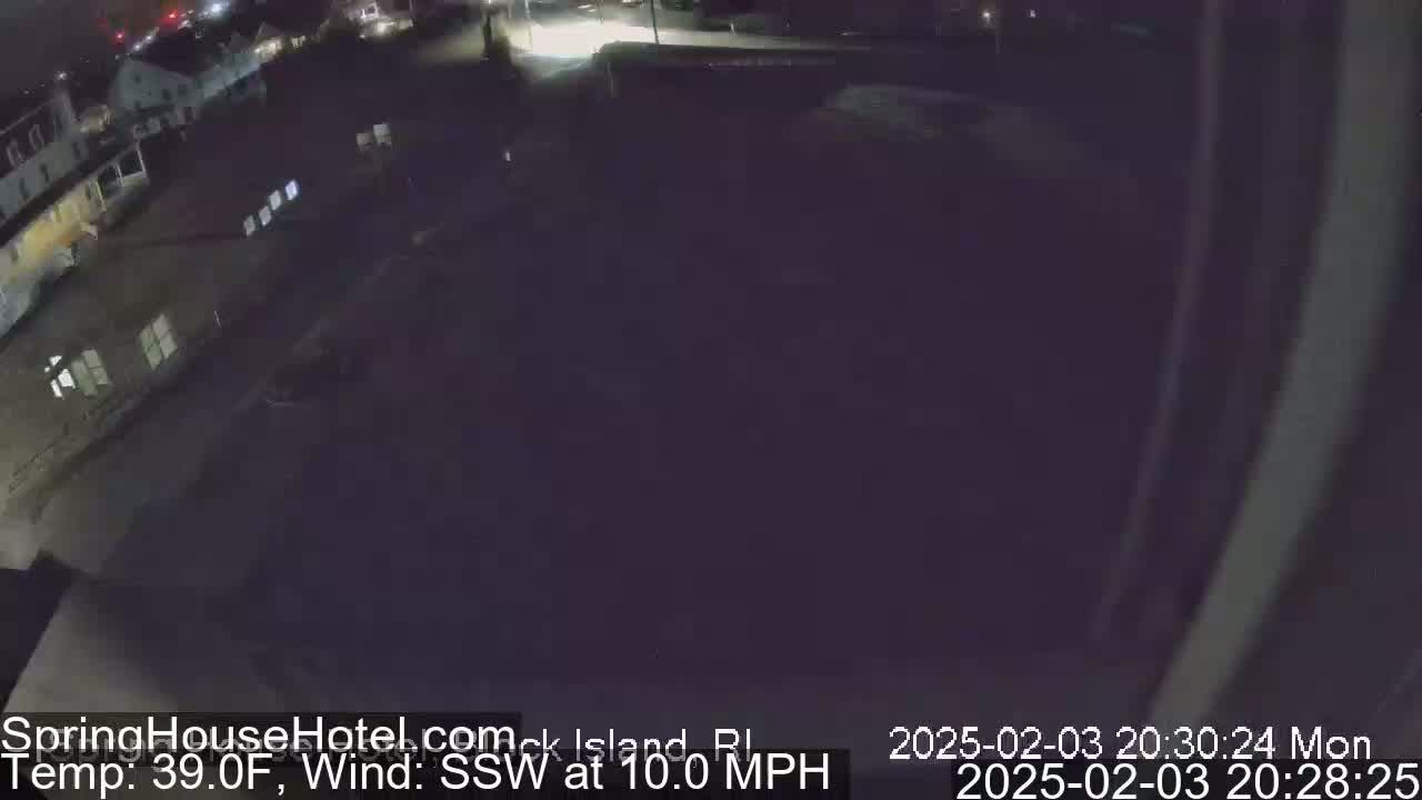 A nighttime, high-angle view of a parking lot and buildings under a dark sky with a 39°F temperature and a 10 mph south-southwest wind.