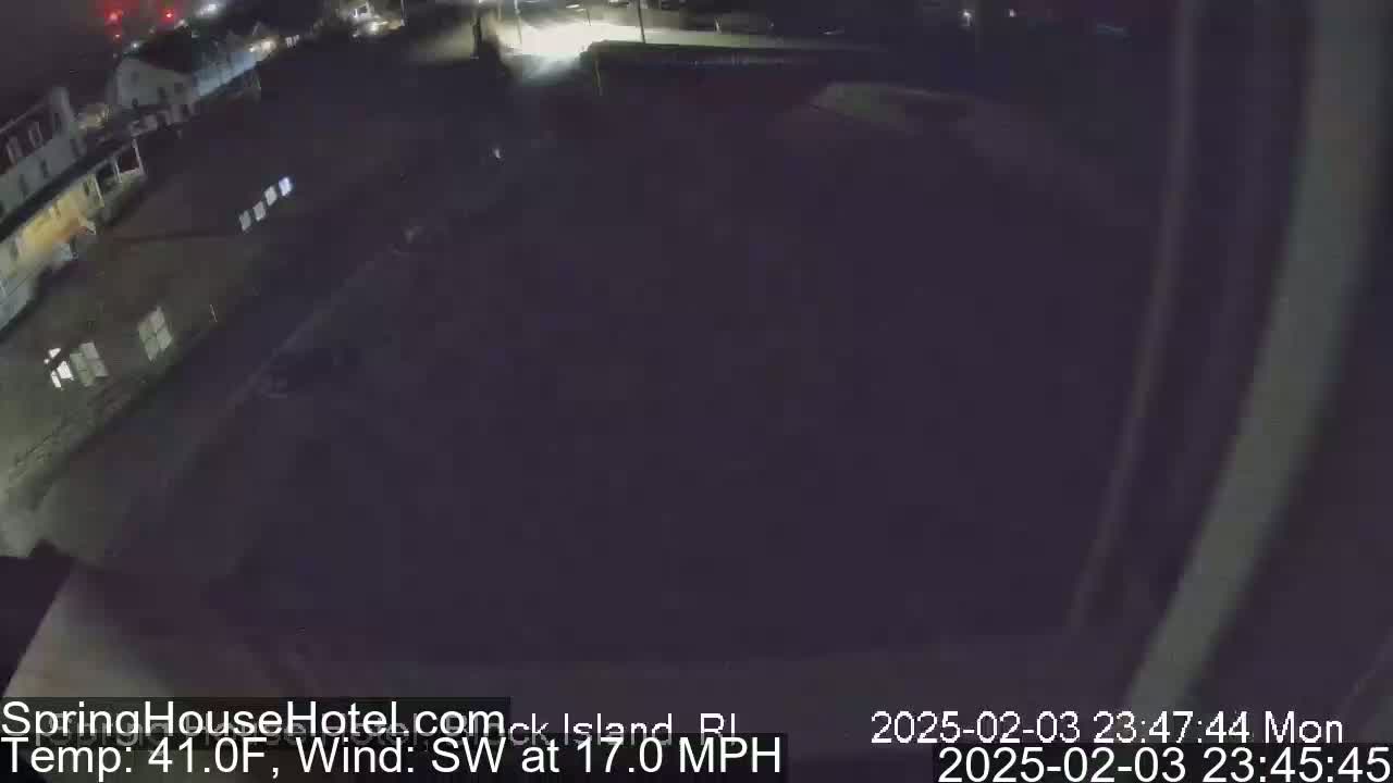 A nighttime, overhead view of a dark, mostly empty parking lot next to buildings, with a southwest wind at 17 mph and a temperature of 41°F.